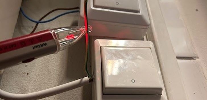 två oskyddade strömförbrytare med felaktigt instalerad elsladd mellan
