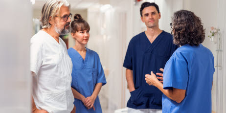 En grupp vårdpersonal står och pratar i en sjukhudkorridor