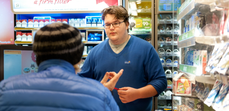 A man stands behind a cash register