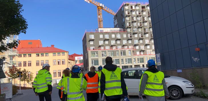 En grupp myndighetskontrollanter i gula västar på en byggarbetsplats.