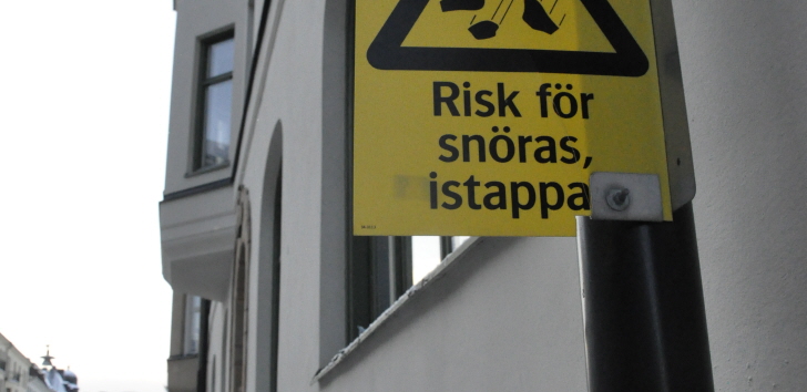 gata vid byggnad med varningsskylt