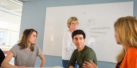 En grupp medarbetare samtalar på ett kontor.