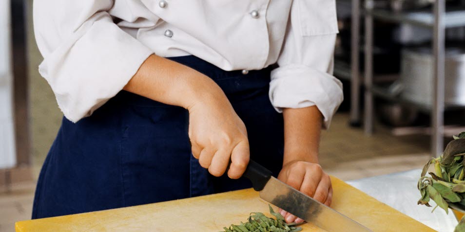 Länk till Arbetsmiljön 2019, bild på en kock som hackar med kockkniv