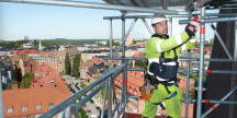 Byggnadsarbetare på byggställning på hög höjd