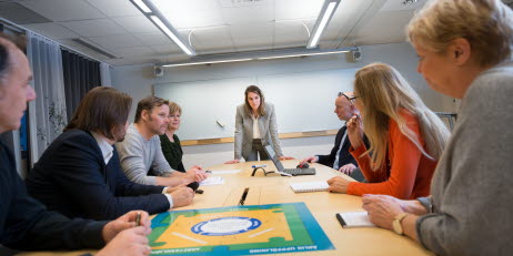 En bild på en grupp människor som sitter på ett möte.