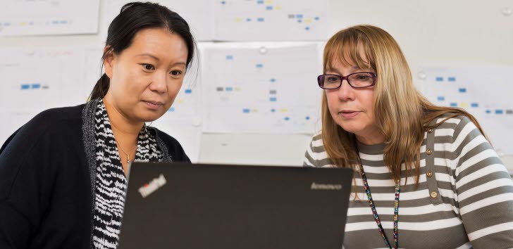 Bild på två kvinnor som tittar på en datorskärm