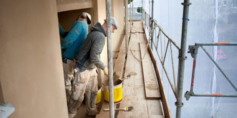 Two construction workers at a building site.