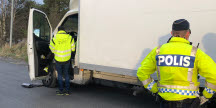 Bild på en inspektör och polis som kontrollerar en lastbil. 