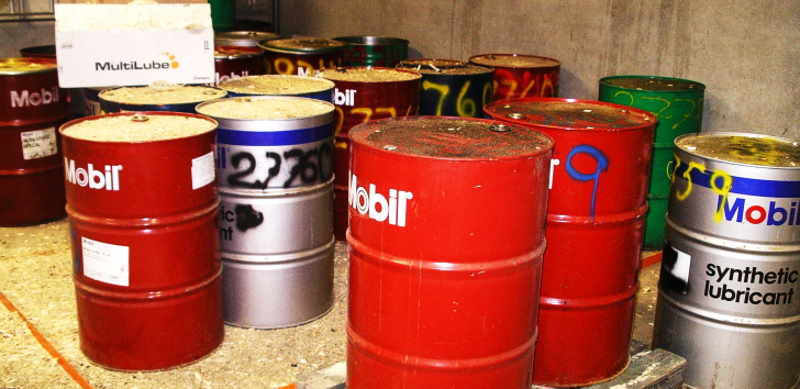 Flera tunnor av plåt med olika typer av vätskor och oljor som innehåll