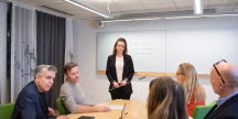 En bild på en grupp människor som sitter på ett möte.