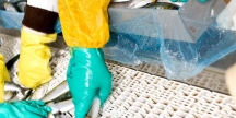 Händer som bär handskar och rensar fisk
