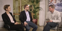 Två personer sitter på stolar och blir intervjuade av en tredje.