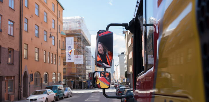 Bild på en bärgningsbils backspegel med en kvinna i.