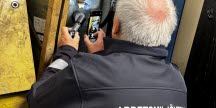 En person från Arbetsmiljöverket använder en mätinstrument och en mobiltelefon vid en inspektion.