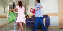 Stressad personal inom vård och omsorg springande i korridor