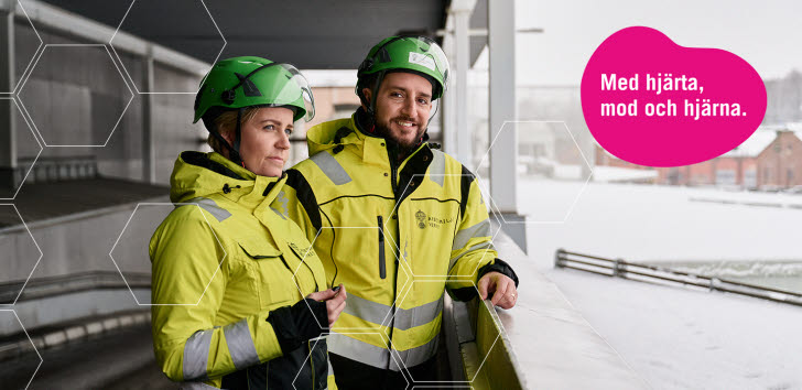 Två arbetsmiljöinspektörer i skyddskläder och hjälm